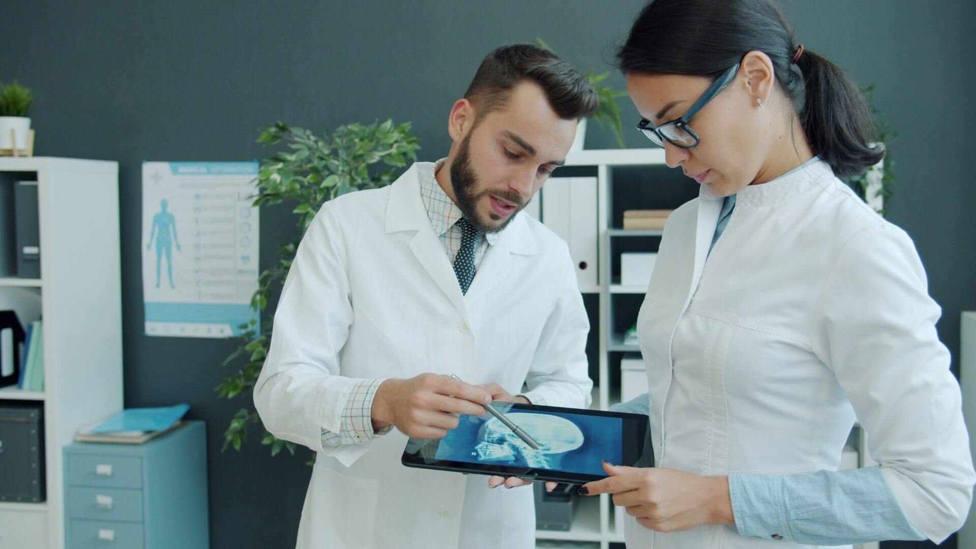 Dos profesionales médicos analizan una imagen clínica en una tablet, una práctica asociada con hospitales inteligentes.