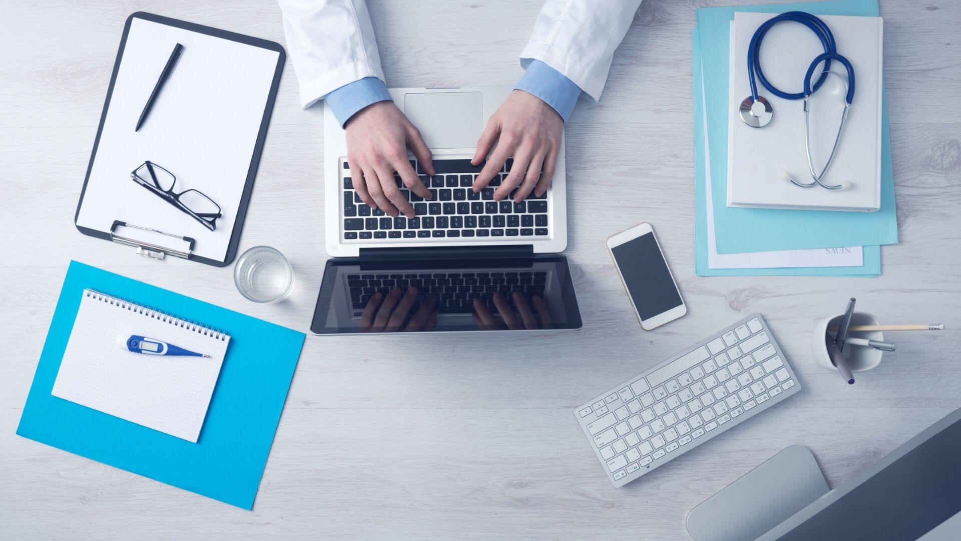 Médico utiliza una computadora rodeado de instrumental clínico, como parte de la transformación hacia hospitales inteligentes.