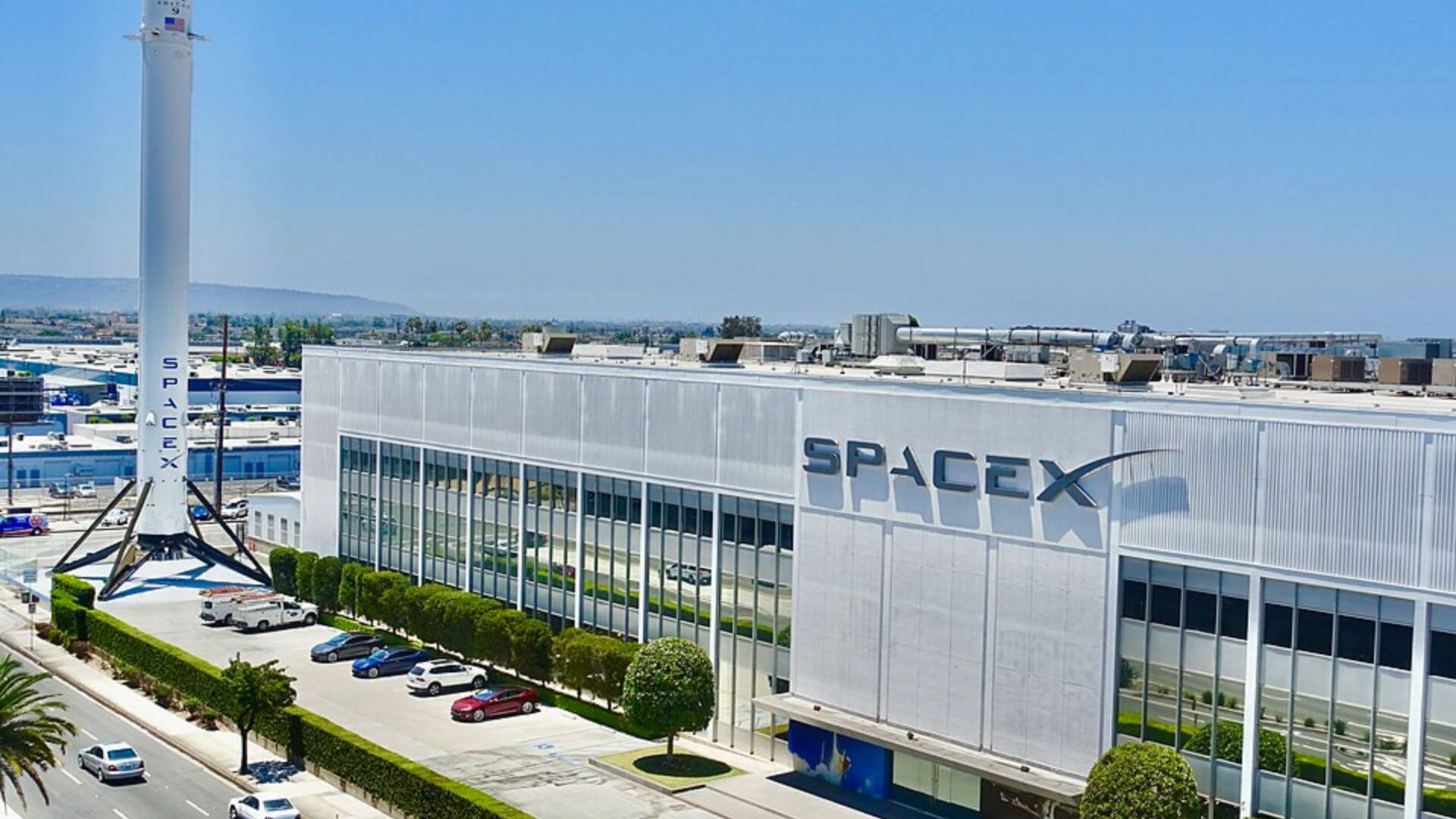 Sede industrial de SpaceX con un cohete vertical instalado junto al edificio principal.