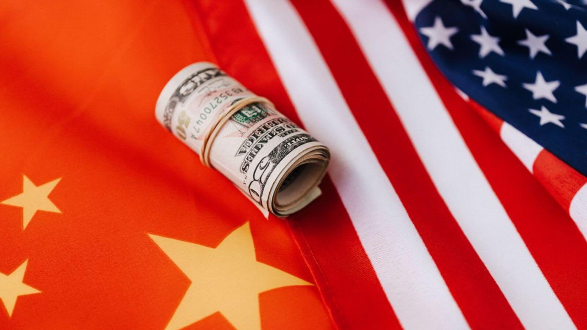Billetes de dólares sobre las banderas de China y Estados Unidos representan el comercio de datos de entrenamiento.
