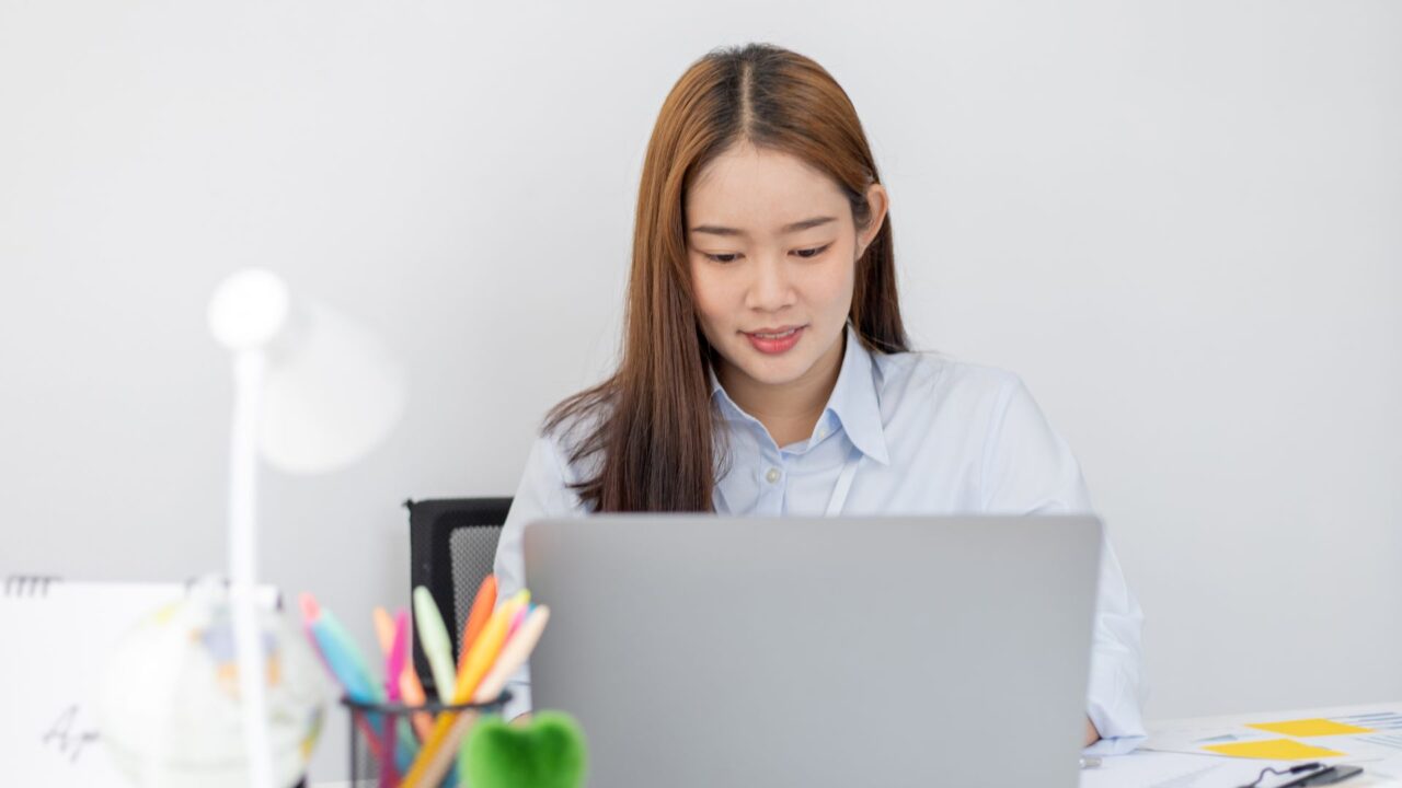 Mujer frente a una notebook en su puesto de trabajo, en una imagen asociada con el empleo en IA y la participación femenina.