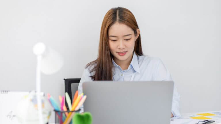 Mujer frente a una notebook en su puesto de trabajo, en una imagen asociada con el empleo en IA y la participación femenina.