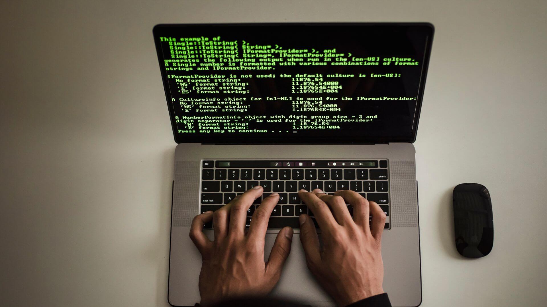 Persona usa una notebook con código en pantalla, una escena asociada al acceso de agentes de IA a sistemas corporativos.