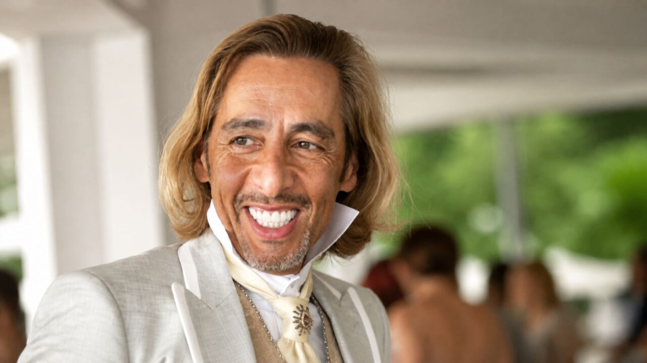 Retrato de un ejecutivo con traje claro y una sonrisa, asociado con la historia empresarial de DDN.