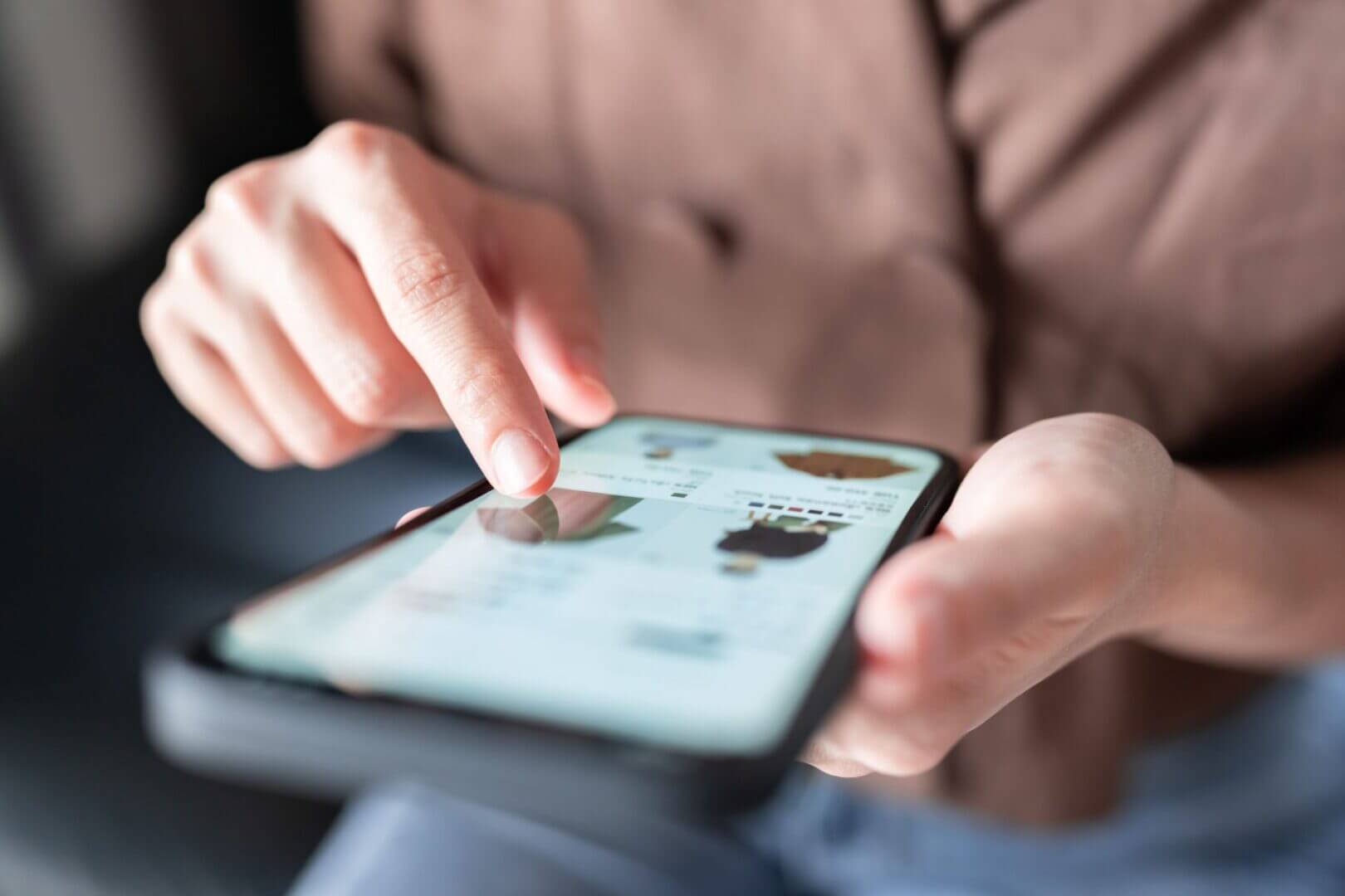 Persona navega productos en un smartphone, una interacción digital utilizada para la personalización en retail.