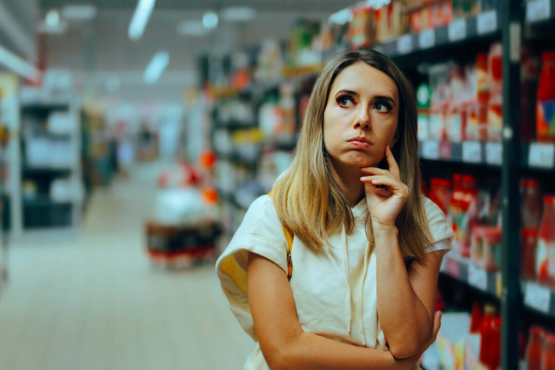 Consumidora evalúa productos frente a una góndola, una escena vinculada con la personalización en retail físico.