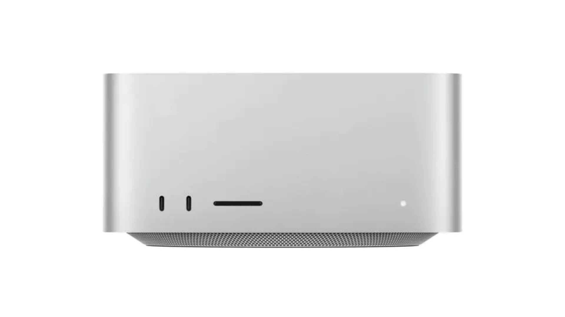 Apple Mac Studio plateada vista de frente, con puertos USB-C, ranura para tarjeta y luz indicadora.