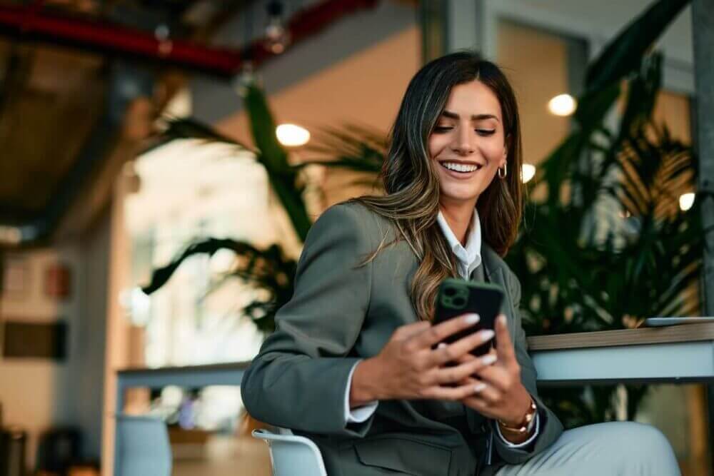 Profesional utiliza un smartphone en un entorno de trabajo, en una imagen asociada a la publicidad digital y la automatización de estrategias.